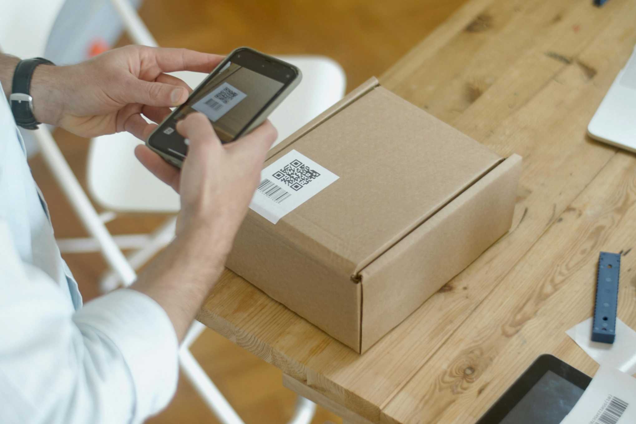 Person scanning a QR code in a small package